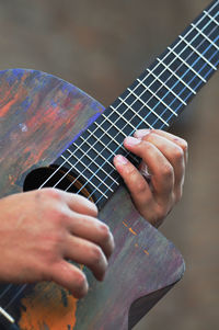 Midsection of man playing guitar