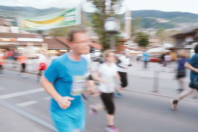 Blurred motion of man walking on road in city