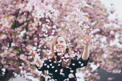 Portrait of smiling girl throwing flower petals