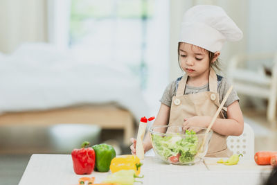 Young woman holding ice cream in kitchen