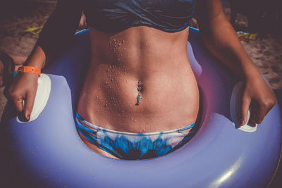 Midsection of young woman in pool raft