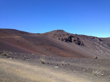 Scenic view of desert against clear blue sky