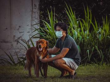 Man with dog sitting on grass