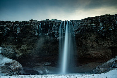 Scenic view of waterfall against sky