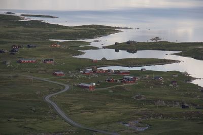 High angle view of buildings on field against water