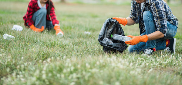 Low section of man collecting garbage from park