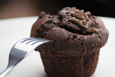 Close-up of chocolate muffin and fork on table