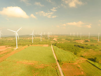 Windmills on field against sky