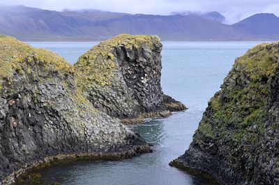 Scenic view of rocks in sea against sky