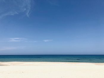 Scenic view of beach against blue sky