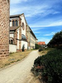 Road amidst buildings against sky