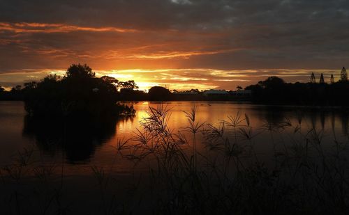 Scenic view of lake against orange sky