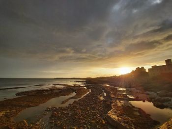 Scenic view of beach against sky during sunset