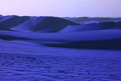 Pop art surreal style royal blue colored desert with fantastic sand ripples and sand dunes