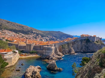 Panoramic view of sea and rocks against blue sky