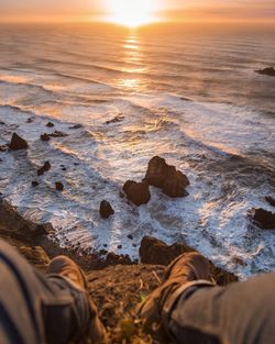 Low section of person at beach during sunset