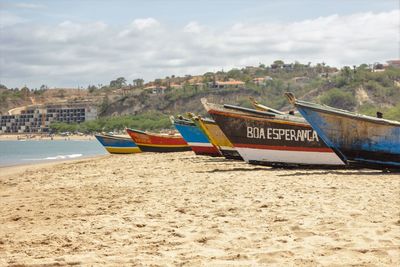 Boats moored on beach against sky