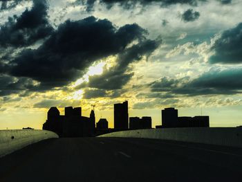 Silhouette of buildings against cloudy sky