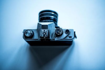 Close-up of camera on table against blue background