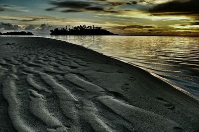 Scenic view of beach against cloudy sky