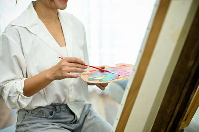 Midsection of woman using digital tablet