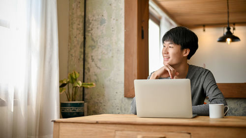 Young woman using laptop at home