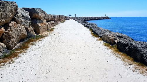 Scenic view of beach against clear blue sky