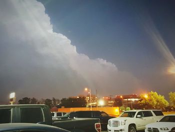 Cars on illuminated city against sky