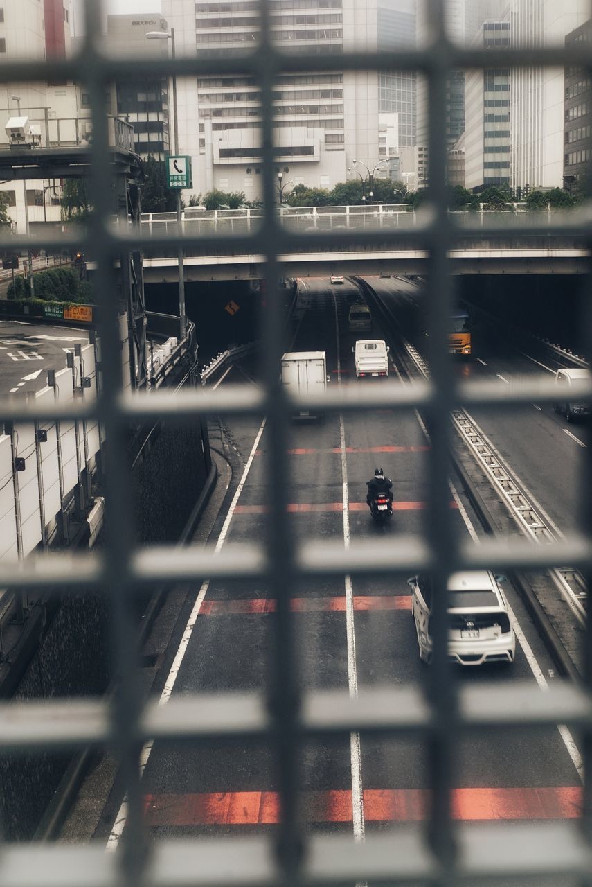 architecture, transportation, rail transportation, built structure, mode of transportation, train, city, building exterior, public transportation, train - vehicle, high angle view, railroad track, track, no people, focus on background, travel, blurred motion, selective focus, motion, day, outdoors