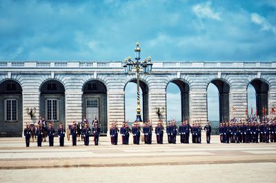 Group of people in front of building against sky