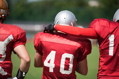 Rear view of american football players on field