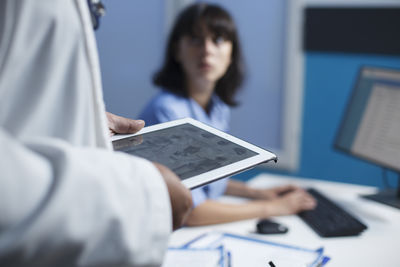 Midsection of man using digital tablet