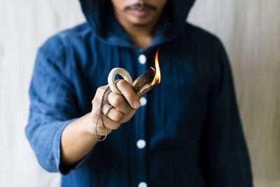 Man person lighting a palo santo and hand holding himalaya salt stone. meditation concept