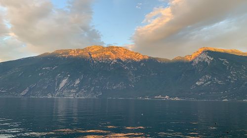 Scenic view of lake by snowcapped mountains against sky