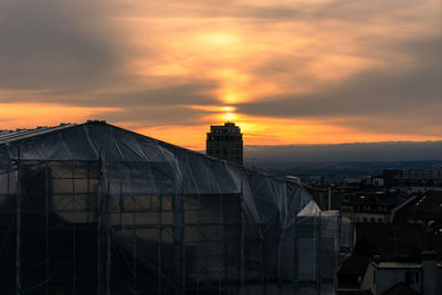 Buildings in city against sky during sunset