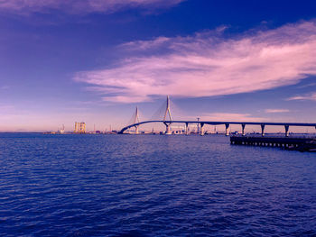 Bridge over sea against sky during sunset