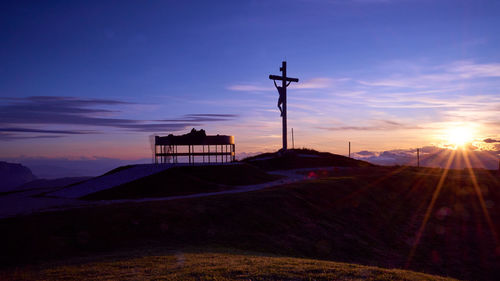 Silhouette built structure on land against sky during sunset