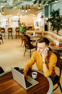 Man using mobile phone in restaurant