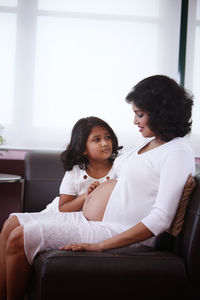 Mother with daughter sitting at home