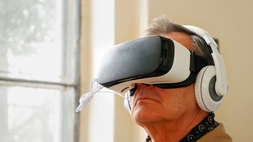 Close-up of senior man looking through virtual reality simulator