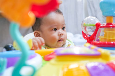 Asian little baby playing with colorful toys at home