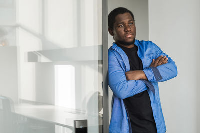 Portrait of pensive african american man looking out window in office thinking making decision