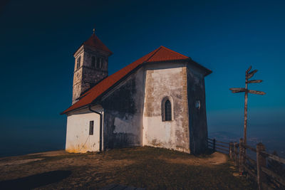 Low angle view of old building against clear blue sky at dusk