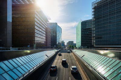 Cars on road amidst buildings in city against sky