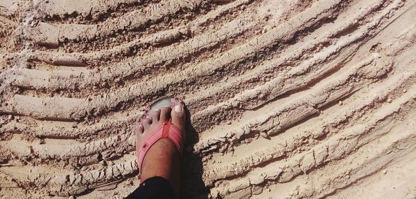 Low section of woman on sand