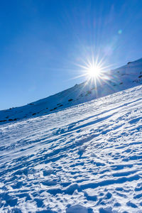 Snow covered mountain against blue sky