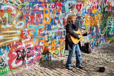 Woman standing against graffiti wall
