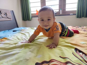 Portrait of cute boy relaxing on bed at home