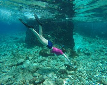 Low section of man swimming in sea