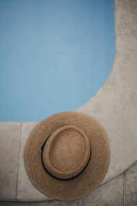 Close-up of hat on table by swimming pool